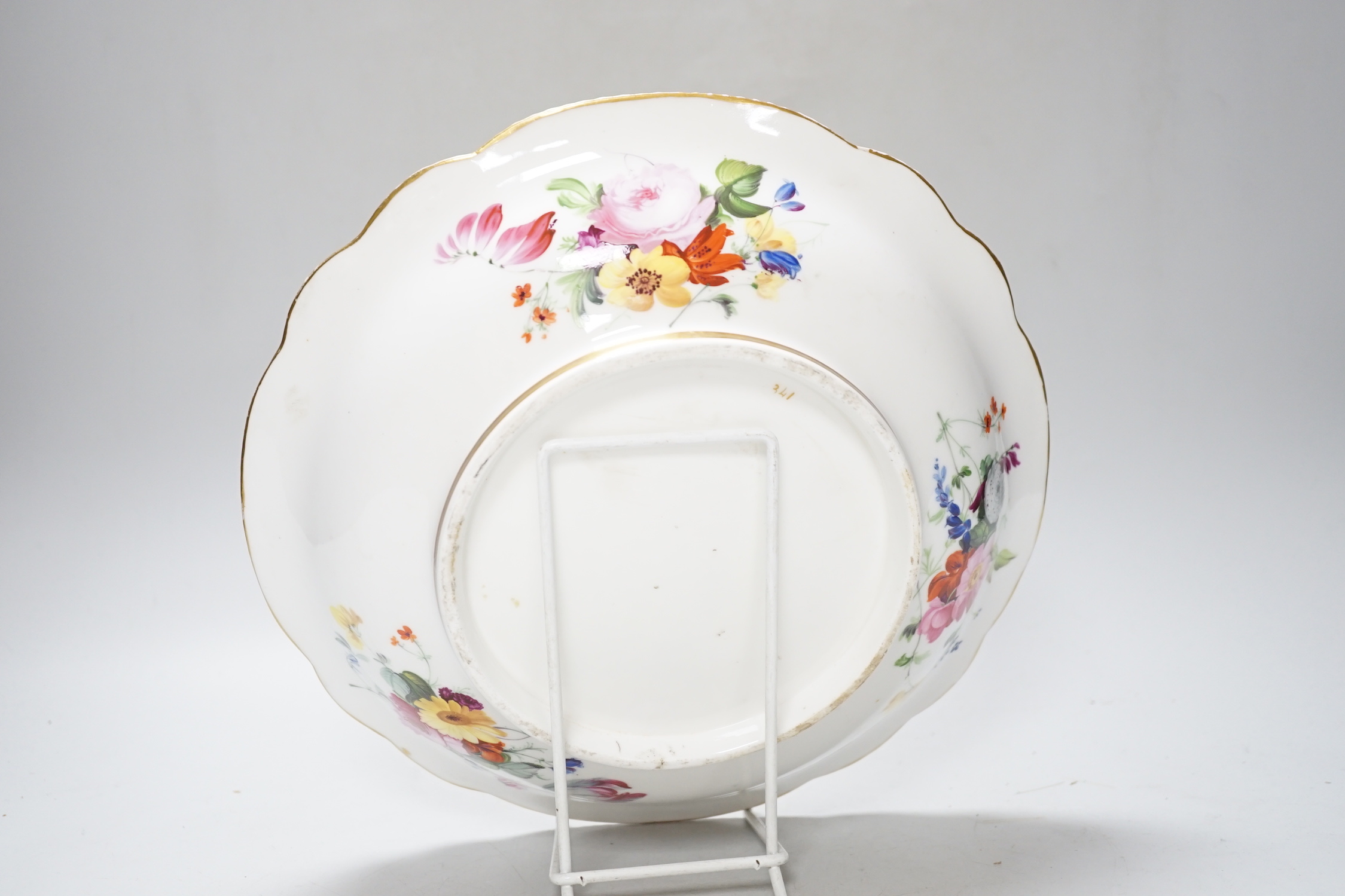 An English porcelain large bowl the centre painted with a bouquet of flowers under a green border with four ornately gilded designs, c.1820, 28cms diameter